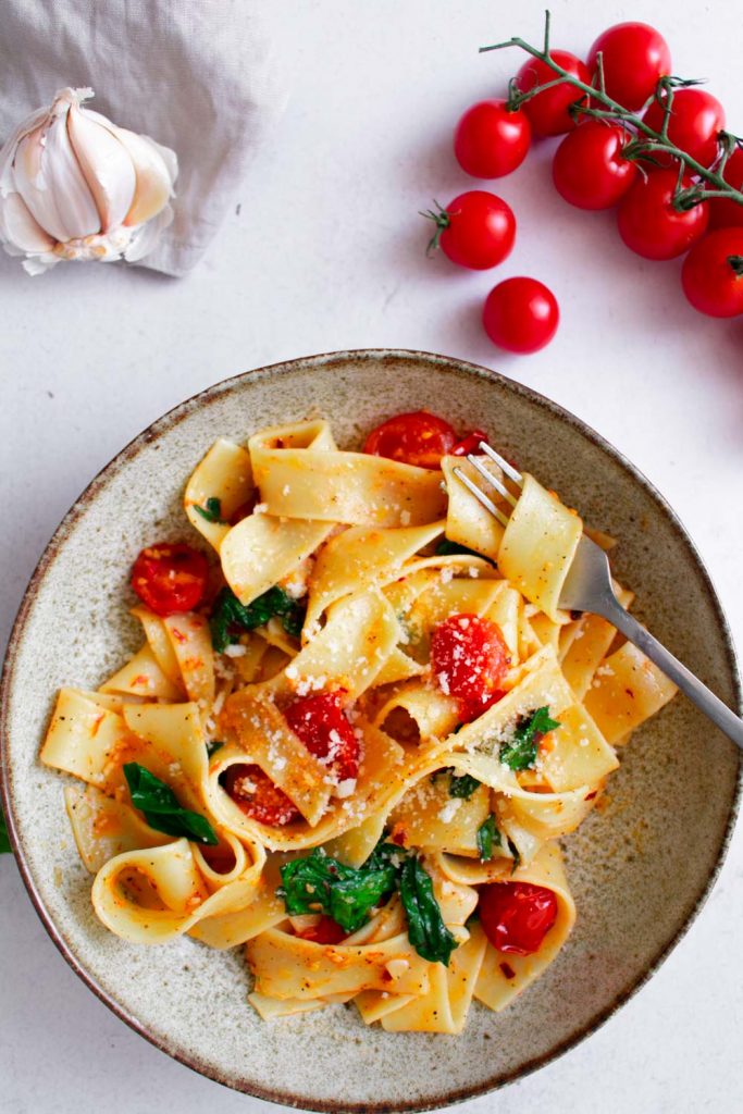 a plate of finished dish of spinach cherry tomato pasta