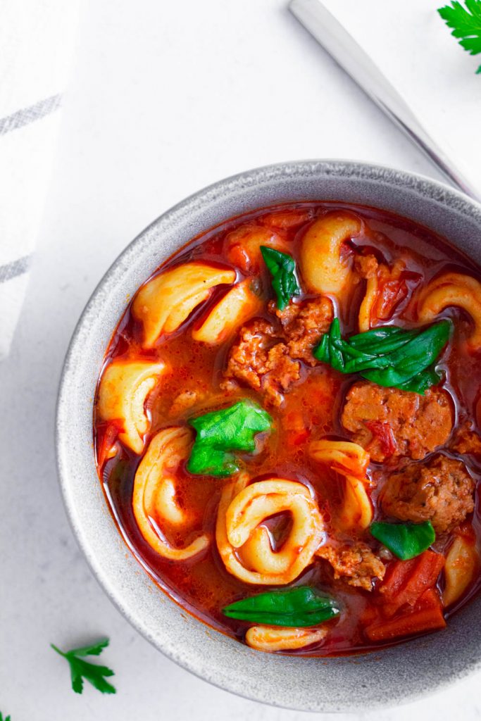 vegetarian sausage spinach tortellini soup served in a bowl