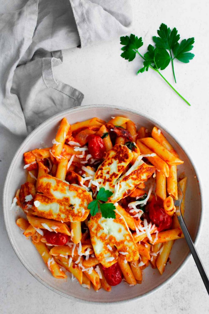 Halloumi Pasta. in a pasta plate on a table with napkin on the side