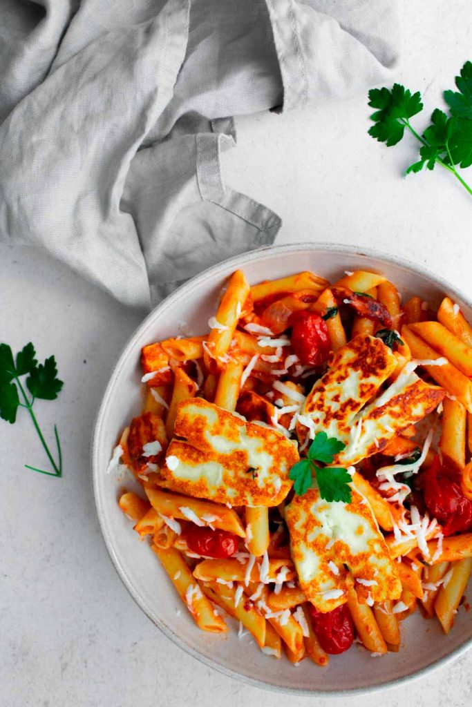 Halloumi with penne pasta cooked in tomato sauce in a bowl