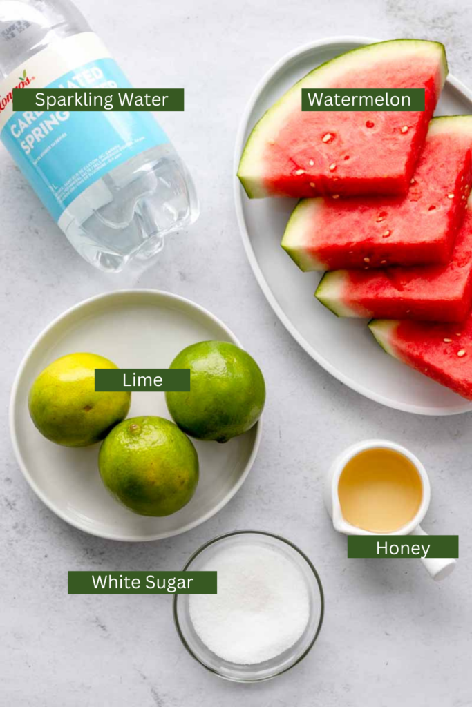 ingredients to make watermelon recipe featuring sparkling water, watermelon slices, lime, agave syrup and white granulated sugar