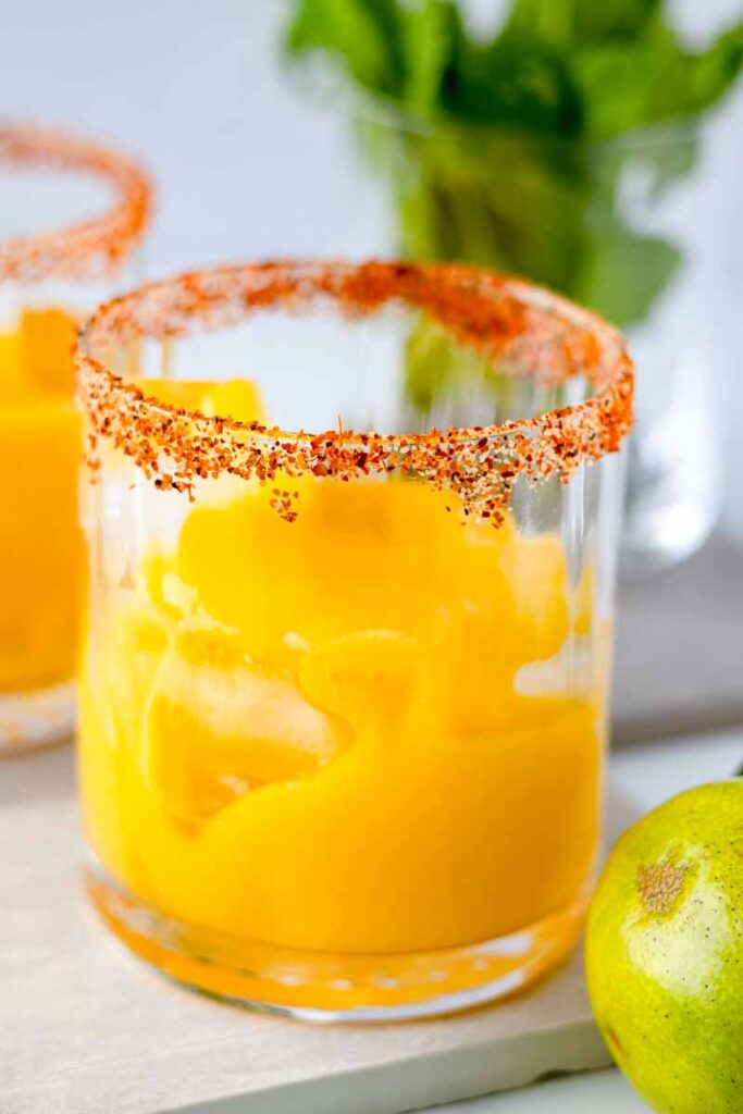 mango puree in glasses with Tajín on their rims