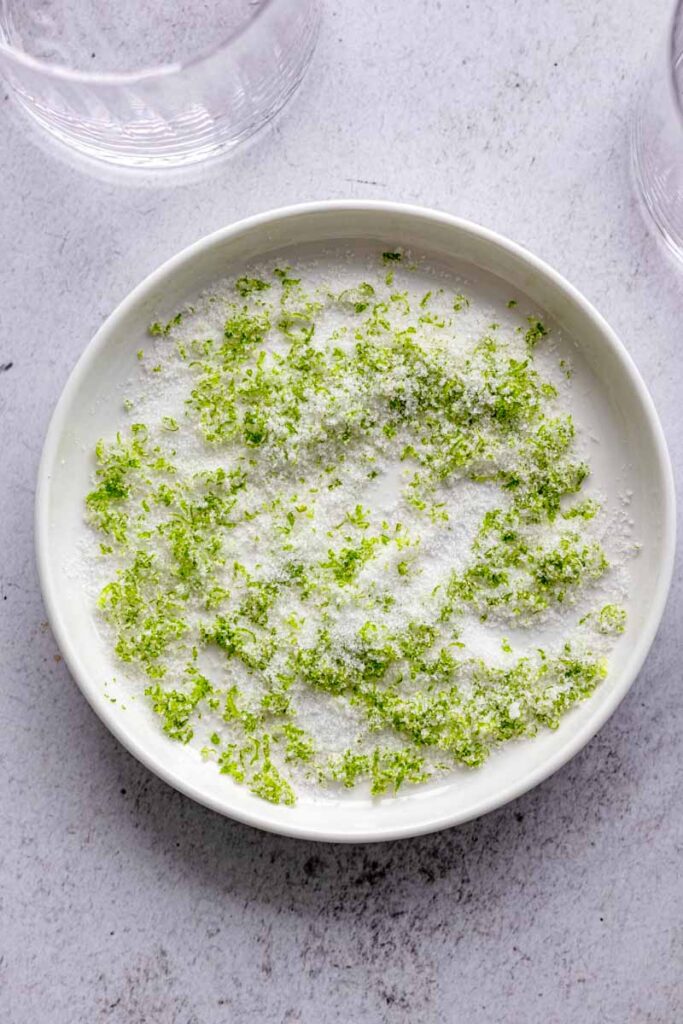 a plate of white sugar mixed with lime zest for glass rim