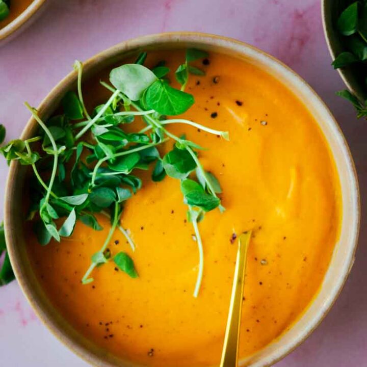 top view of carrot and golden beet soup with fresh herbs