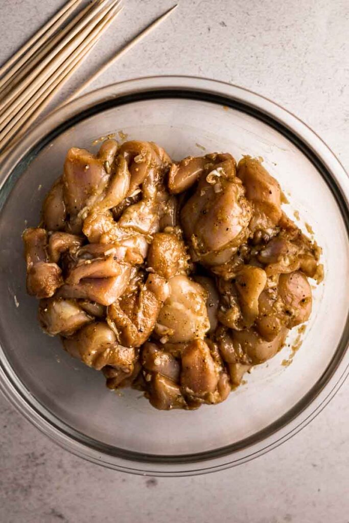 chicken mixed with lemongrass marinade in a bowl