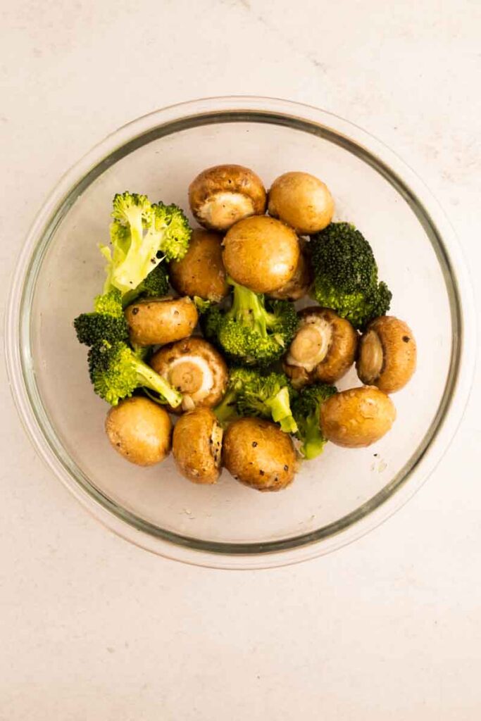 broccoli and mushrooms combined with garlic and butter in a bowl