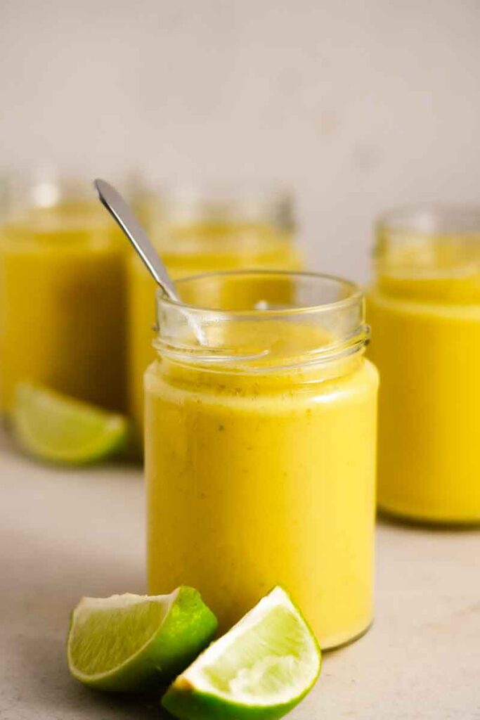 a close up of pear mango smoothie in a jar