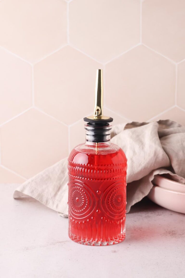 bright pink raspberry syrup in a glass bottle