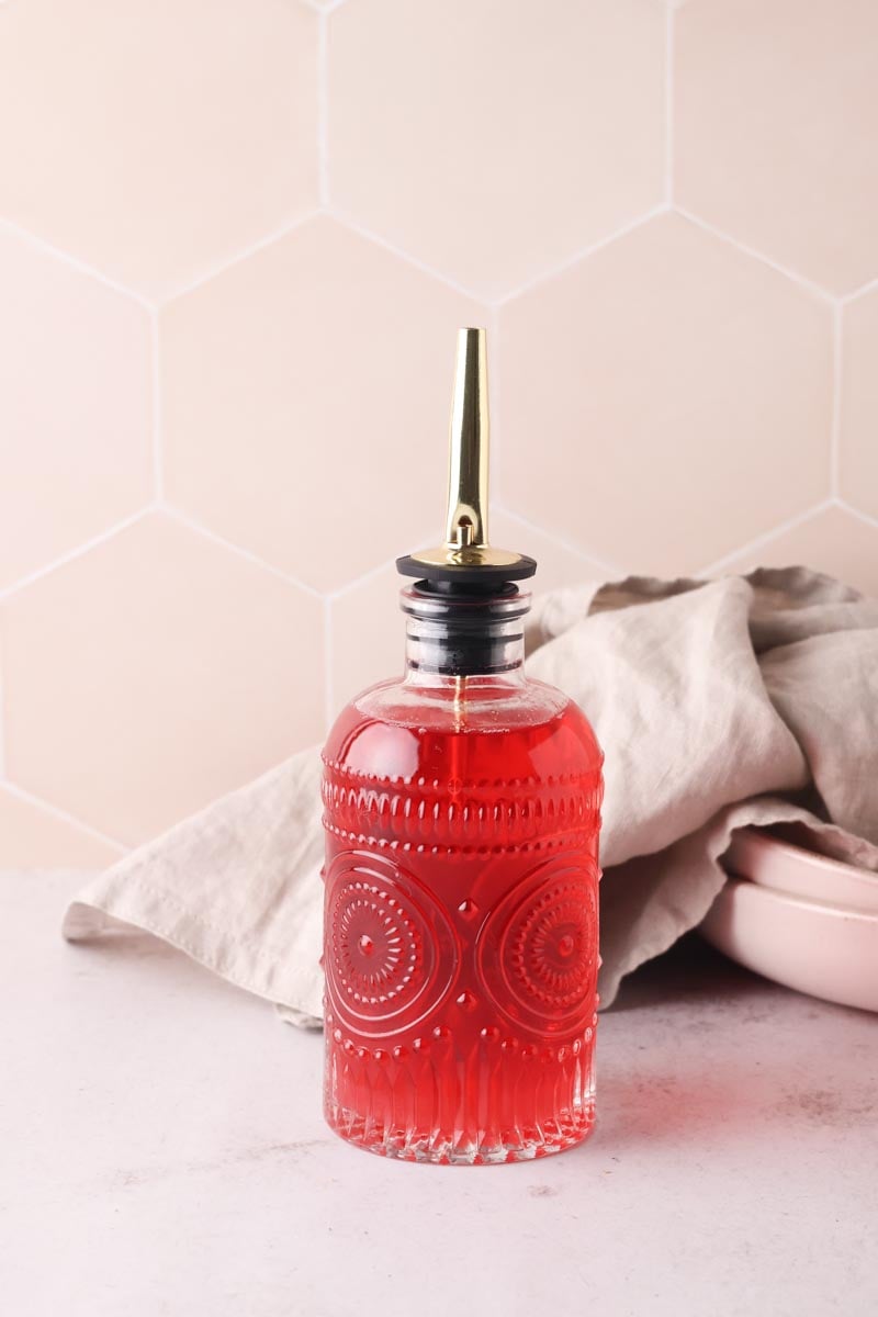 bright pink raspberry syrup in a glass bottle